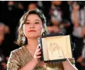  ??  ?? Hong Kong director Tang Yi poses with her trophy during a photocall after she won the Palme d’Or - Short Film for her film “All the Crows in the World”.