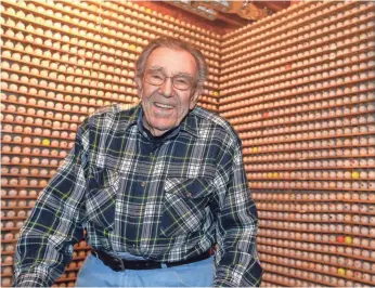  ??  ?? When Don Thompson retired 31 years ago, he began collecting golf balls with logos on them. He now has over 15,000 on display racks in his basement.