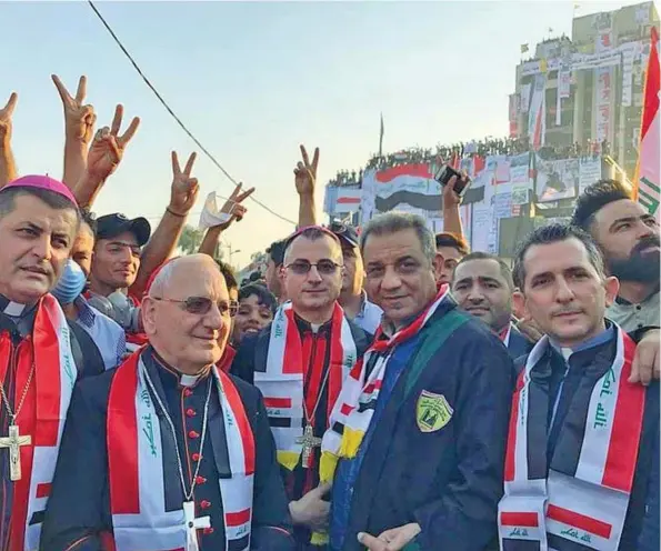  ??  ?? L’immagine
Il cardinale Louis Raphaël I Sako (secondo da sinistra) tra i manifestan­ti di piazza Tahrir a Bagdad