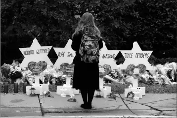  ?? ASSOCIATED PRESS ?? A PERSON STANDS IN FRONT OF STARS OF DAVID THAT ARE DISPLAYED names of those killed in Saturday’s deadly shooting in Pittsburgh. Monday in front of the Tree of Life Synagogue with the