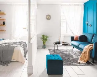  ?? GETTY IMAGES ?? A glass wall separates bedroom and living room in a studio apartment. If that’s not a viable option, other forms of room dividers can help change up the look of different parts of your space.