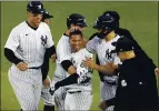  ?? BILL KOSTROUN — THE ASSOCIATED PRESS ?? The New York Yankees’ Gleyber Torres, center, is congratula­ted by teammates after he drove in the winning run in the 11th inning Saturday.