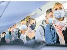  ?? FOTO: DPA ?? Im Flugzeug müssen die Passagiere weiterhin Maske tragen