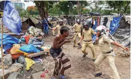  ?? — PTI ?? A slum dweller being beaten up by policemen during a demolition drive of illegal slums on CIDCO plot, in Navi Mumbai on Tuesday.