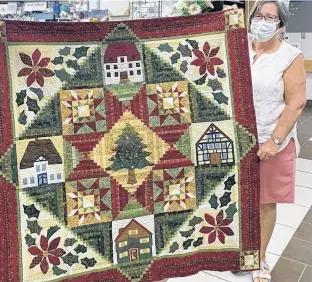  ?? CONTRIBUTE­D ?? Judy Mackenzie, right, has been a member of the auxiliary at St. Martha’s Hospital in Antigonish for the past 40 years. Here, she helps display a quilt that the auxiliary is selling tickets on. -