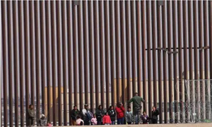  ?? Photograph: Hérika Martínez/AFP/Getty Images ?? Texas national guard agents process families after they crossed the El Paso sector border and the Rio Grande on 29 February 2024.