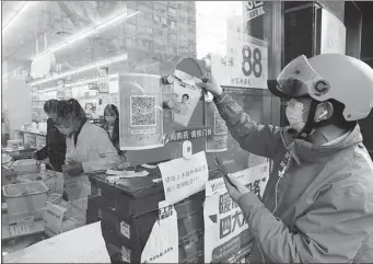  ?? ZHU XINGXIN / CHINA DAILY ?? A deliveryma­n picks up products at a drug store in Shanghai in April.