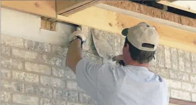  ?? EE ?? Un albañil repara la fachada del edificio de una comunidad de vecinos.