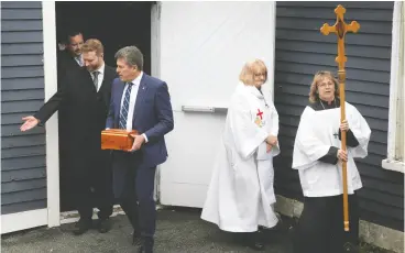  ?? PAUL DALY / THE CANADIAN PRESS ?? Bob Andrews carries the urn with the ashes of his uncle, legendary sportscast­er Bob Cole, as he leaves Cole’s memorial service in St. John’s, N.L., Friday.