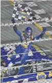  ?? THE ASSOCIATED PRESS ?? Chase Elliott celebrates while standing on his car after taking the checkered flag from an official following his win in the first of two Can-Am Duels on Thursday night.