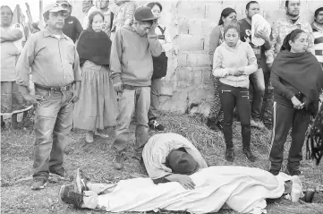  ??  ?? File photo shows people standing before the body of a person killed during a clash between villagers and state police officers in Arantepacu­a, Nahuatzen municipali­ty, Michoacan state, Mexico. — AFP photo
