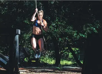  ?? Photograph­s by Gina Ferazzi Los Angeles Times ?? NINJA WARRIOR contestant Jessie Graff, who also works as a stuntwoman, swings from a rope in Scotts Valley, Calif., while practicing with other contestant­s for the finals of the “American Ninja Warrior” show.