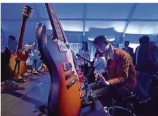  ?? FOTO: PAUL BUCK/DPA ?? Ein Besucher der Consumer Electronic­s Show 2016 spielt im Zelt des Gitarrenhe­rstellers Gibson auf einer Gitarre. Zu der Zeit konnte sich wohl niemand vorstellen, dass Gibson bald vor dem Aus stehen könnte.