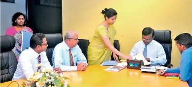  ??  ?? Picture shows BOI Chairman Upul Jayasuriya signing an agreement in the presence of Micro Holdings Chairman Dr. Lawrence Perera and officials.