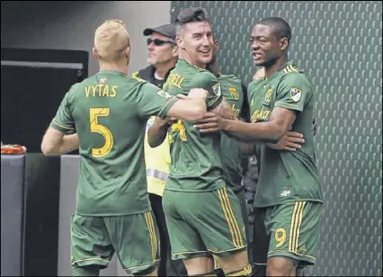 ?? SEAN MEAGHER / THE OREGONIAN ?? Portland Timbers players celebrate a set-piece goal by Liam Ridgewell (center) against visiting Atlanta United in Sunday’s 1-1 draw.