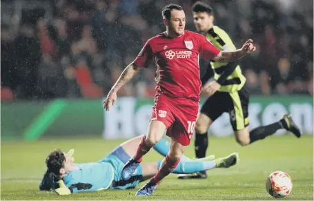  ??  ?? Bristol City’s Lee Tomlin beats keeper Danny Ward to hit the first of the Robins’ four goals against Huddersfie­ld in the Championsh­ip last night