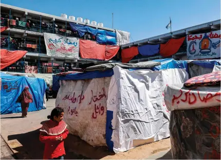  ?? AFP PHOTO ?? REFUGEE CAMP
Greetings for the Muslim holy month of Ramadan hang at a refugee camp run by the United Nations Relief and Works Agency in Rafah, southern Gaza Strip, on Wednesday, March 13, 2024.