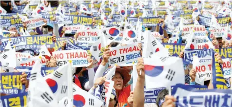  ?? — Reuters ?? Seoungju residents chant slogans during a protest against the government’s decision on deploying a US THAAD anti-missile defence unit in Seongju, in Seoul, South Korea, on Thursday. The banner reads ‘Desperatel­y oppose deploying THAAD’.