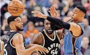  ?? [PHOTO BY THE CANADIAN PRESS VIA THE ASSOCIATED PRESS] ?? Oklahoma City’s Russell Westbrook, right, passes the ball while Toronto’s Cory Joseph, left, and Patrick Patterson defend during Thursday night’s NBA game at Air Canada Centre. The Thunder whipped Toronto, 123-102.