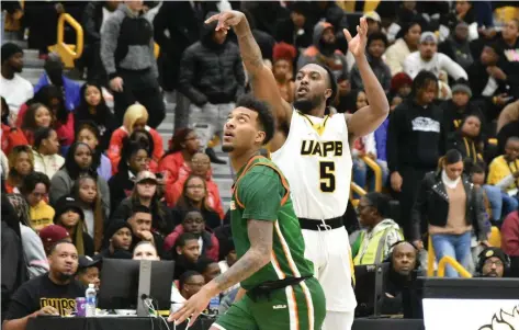  ?? (Pine Bluff Commercial/I.C. Murrell) ?? Rashad Williams of UAPB fires a 3-point shot over Roderick Coffee III of Florida A&M in the first half Saturday at H.O. Clemmons Arena.
