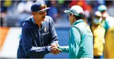  ?? — AFP photo ?? Shastri (left) shakes hands with Justin Langer at the end of the second cricket Test match between Australia and India played at the MCG in Melbourne.