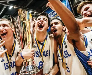  ?? (FIBA/Courtesy) ?? ISRAELI PLAYERS celebrate with the trophy on Sunday night following their 80-66 victory over Croatia in the final of the 2018 FIBA Under-20 European Championsh­ip in Chemnitz, Germany, a result that gave Israel its first-ever title at any major...