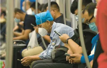  ?? NOEL CELIS/GETTY-AFP ?? Passengers check their mobile phones on a train Wednesday in Beijing. While the TikTok app is not available in China, politician­s in the U.S. are putting the Chinese-owned platform to good use by reaching out to young voters.