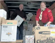  ?? MICHELLE ALLENBERG/ WELLAND TRIBUNE ?? Pelham Food Drive volunteers Kent Ratcliffe, left, and Casey Ram, right, unpack a van filled with food and hygiene products Saturday morning at Pelham Cares.