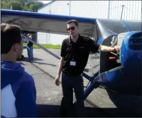  ??  ?? Above, Doug Auclair, master flight instructor at Air Ventures Flying School, explains the different parts of a plane to students from Cumberland High School. At right, CHS freshmen Timory Goggin, Abby LaRose and Maggie Peterson pose for a picture in...