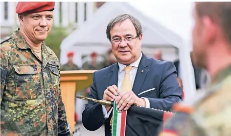  ?? RP-FOTO: JANA BAUCH ?? Ministerpr­äsident Armin Laschet (r.) verleiht dem Feldjägerr­egiment 2 das Fahnenband NRW. Links Kommandeur Oberstleut­nant Björn Taube.