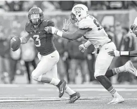  ?? Joe Sarugent / Getty Images ?? West Virginia quarterbac­k Skyler Howard (3) eludes TCU defender Josh Carraway in the second quarter of Saturday’s game at Morgantown, W.Va.