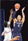  ?? Charles Rex Arbogast / Associated Press ?? UConn’s Tyrese Martin (4) shoots over DePaul’s Romeo Weems on Monday.