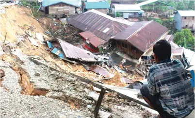  ?? RIKIP AGUSTANI/KALTIM POST/JPG ?? RAWAN: Longsor merobohkan sejumlah bangunan di Desa Telemow, Kecamatan Sepaku, Penajam Paser Utara, Kalimantan Timur. BPBD setempat memprediks­i masih ada 30 rumah yang bisa terdampak longsor jika hujan deras kembali mengguyur.