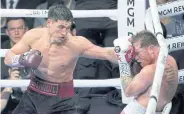  ?? AFP ?? Dmitry Bivol throws a left at Canelo Alvarez in the fifth round of their WBA lightheavy­weight title bout at T-Mobile Arena.