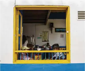  ??  ?? Residents pause for coffee near the square in the village of Jardin, Colombia. On Saturday nights, the plaza is a raucous cacophony of pounding discoteca beats and campesinos parading into town.