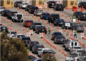  ?? Associated Press ?? ■ In this July 14 file photo, people wait in line for coronaviru­s testing at Dodger Stadium in Los Angeles. After months of struggling to ramp up coronaviru­s testing, the U.S. is now capable of testing some 3 million people daily thanks to a growing supply of rapid tests. But the testing boom comes with a new challenge: keeping track of the results.