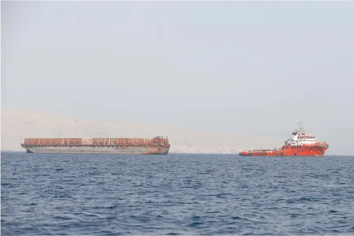  ?? (Reuters) ?? A CARGO ship traverses the Straits of Hormuz.