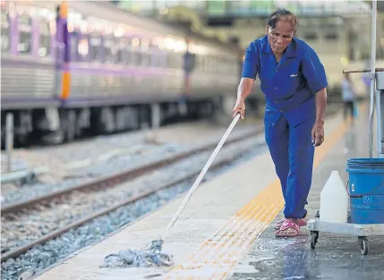  ?? PATIPAT JANTHONG ?? A female cleaner works at a train station. Demands from less fortunate women remain unanswered although female policymake­rs have a say in women’s issues.