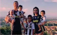  ??  ?? L’ALIENO IN FAMIGLIACr­istiano con la fidanzata Georgina Rodriguez, 24 anni, e i 4 figli tutti vestiti di bianconero nella nuova casa dietro alla Gran Madre