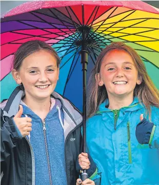  ??  ?? Twin sisters Bethany, left, and India Hughes, 12, from Dunblane, weren’t put off by the poor weather at Scone Palace.
