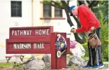  ?? JOSH EDELSON THE ASSOCIATED PRESS ?? Resident Tom Parkinson places flowers Saturday on a sign at the Veterans Home of California, the morning after a hostage situation there.
