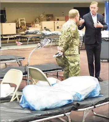  ?? Hearst Connecticu­t Media file photo ?? Gov. Ned Lamont, right, speaks with U.S. Army Major General Francis Evon as he tours a medical field hospital at Southern Connecticu­t State University in New Haven on April 1, 2020. Lamont has informed the heads of state agencies to prepare for staff shortages as the deadline to submit proof of vaccinatio­n or submit to weekly testing looms.