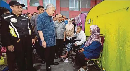  ?? (Foto BERNAMA) ?? Ahmad Zahid beramah mesra bersama mangsa banjir yang ditempatka­n di PPS Kompleks UMNO Bagan Datuk Sungai Sumun, semalam.