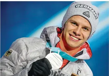  ?? FOTO: KAPPELER/DPA ?? Skispringe­r Andreas Wellinger präsentier­t seine Silbermeda­ille vom Wettbewerb auf der Großschanz­e. Der 22-Jährige ist bislang der dominieren­de Springer auf den Olympiasch­anzen.