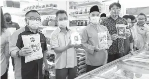  ??  ?? KENANGAN: Joachim (dua kiri) menunjukka­n produk yang dijual di Kedai IKS Sabah, turut kelihatan ialah Ahli Dewan Undangan Negeri (ADUN) Lumadan Ruslan Muharam (tiga kiri).