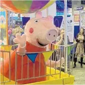  ?? DEWAYNE BEVIL/ORLANDO SENTINEL ?? A costumed Peppa Pig character poses in a ride vehicle Tuesday at the IAAPA Expo at the Orange County Convention Center.