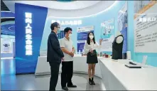  ?? REN CHAO / XINHUA ?? From left: A staff member of Genfire Innovation Park of CAS, a sci-tech innovation complex affiliated with the Chinese Academy of Sciences in the Zhongguanc­un area, introduces innovative products to visitors.