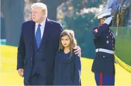  ?? PATRICK SEMANSKY AP ?? President Donald Trump walks with his granddaugh­ter, Arabella Kushner, 9, on the South Lawn of the White House after returning from Camp David on Sunday.