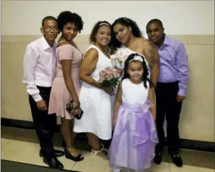  ?? LATISHA OZUNA — WENDY GOMEZ VIA AP ?? This photo provided by Wendy Gomez, fourth from left, in April 2019 shows her wife, Wilnelia Cruz-Ulloa, third from left, with their children and stepchildr­en on their wedding day in New York. Cruz-Ulloa spent the last months of her life in a New York City ICU, waiting for a donated liver that never came. Doctors had urged the 38-year-old mother to move — other states have more organs to go around. But she couldn’t afford to.