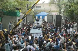  ?? K.M. CHAUDARY/AP ?? A vehicle carrying former Prime Minister Imran Khan is surrounded by his supporters Saturday as he leaves for Islamabad from his residence in Lahore, Pakistan.